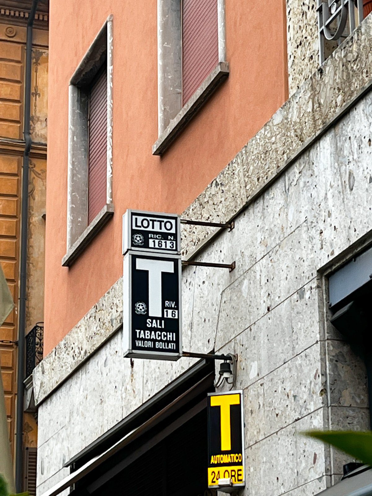 Sign for a tabaccheria in Italy, where you can buy bus tickets, stamps, and cigarettes.